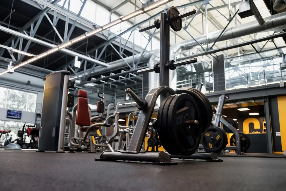 Weight plates and fitness equipment in a modern indoor gymnasium sports center for physical training and assessments.