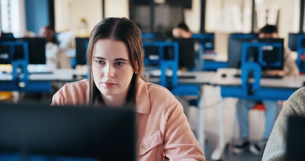 Focused candidate taking a mechanical aptitude technical test on a computer screen in a testing center.