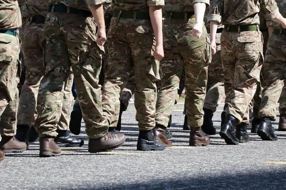 Soldiers in military uniforms marching in formation as part of their training for a career in the defense force.