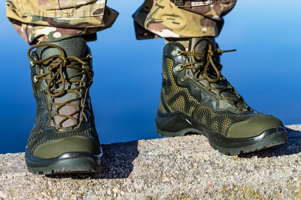 Olive green military boots and camo pants, essential army gear for recruits during induction day and initial training.