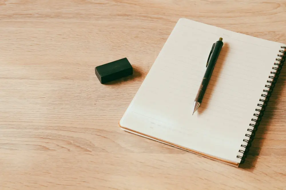 Mechanical pencil and eraser on a spiral notebook, ready for writing study notes and methodical test preparation.