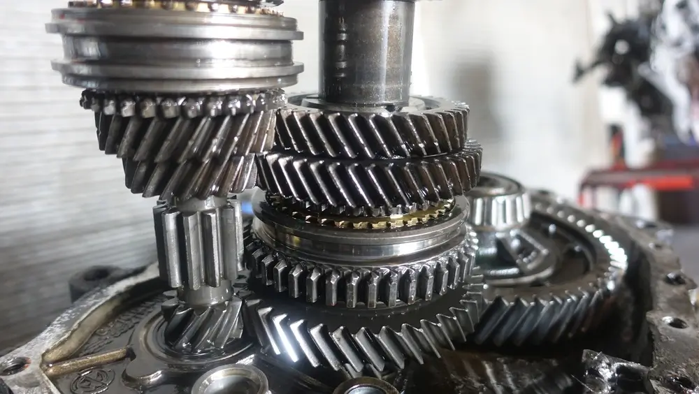 Meshed steel industrial gears and mechanical parts forming a heavy industrial gear mechanism.