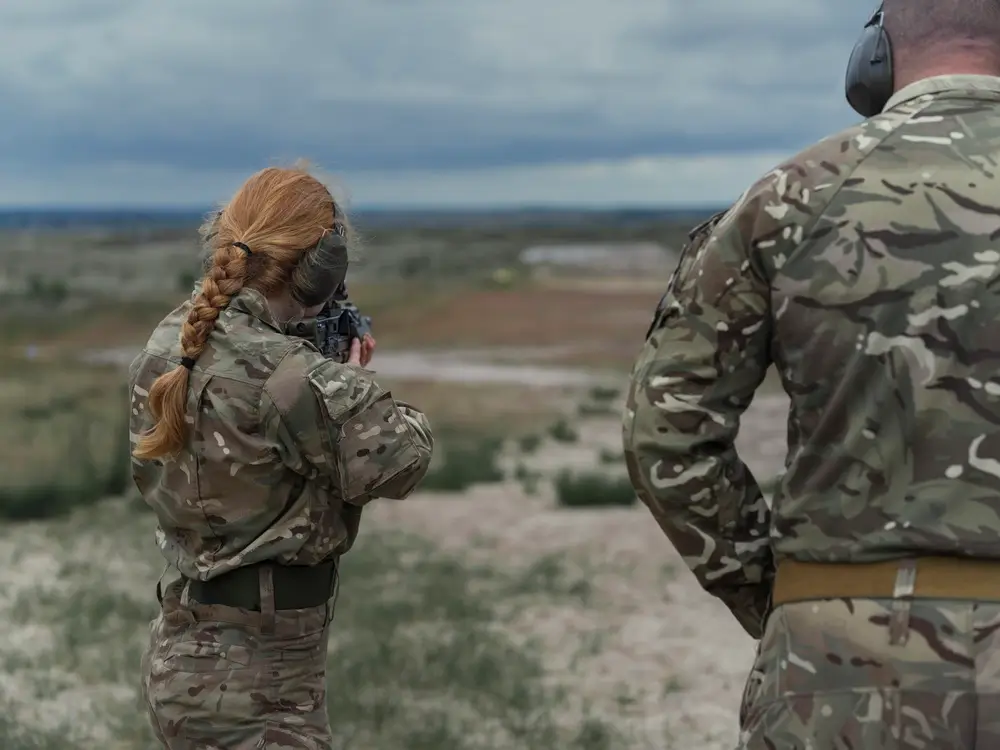 Soldiers practicing weapon handling during a military training session at an outdoor shooting range.