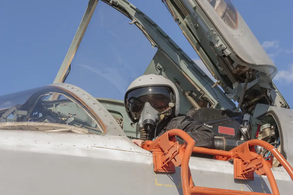 RNZAF military pilot wearing a flight helmet and mask inside the cockpit of a military aircraft.
