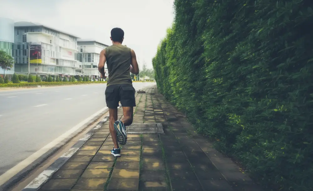 A recruit running on a sidewalk to prepare for military fitness training and the army fitness test recruitment.