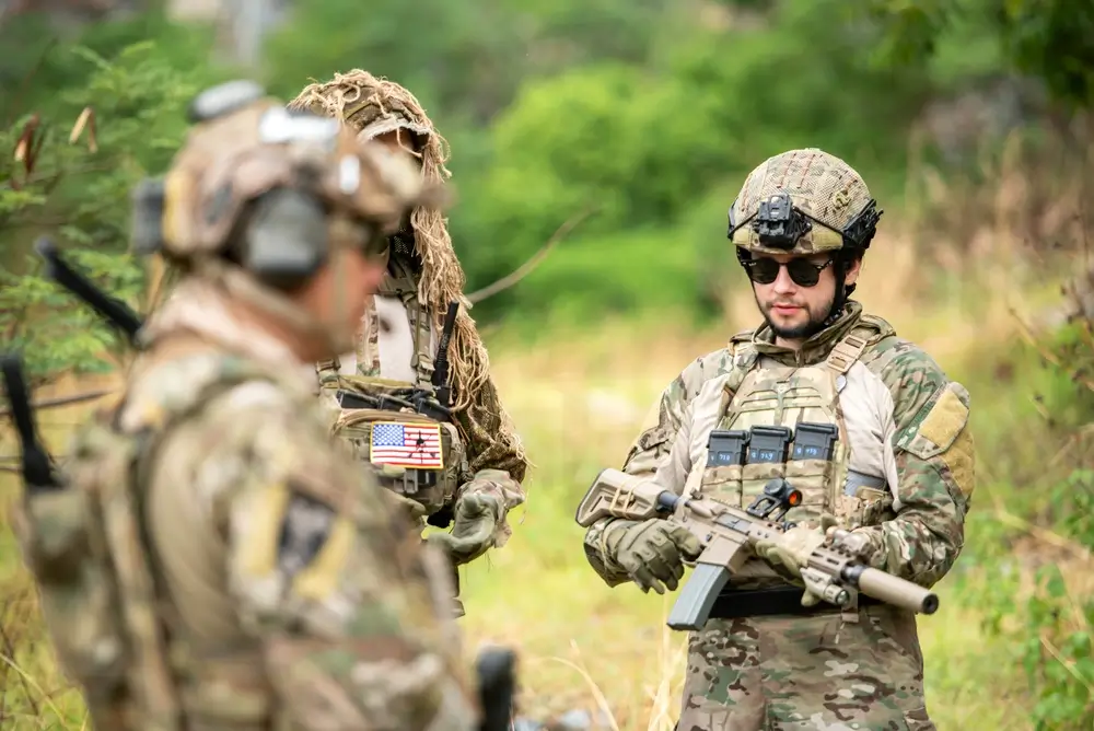NZDF soldiers in New Zealand during a military deployment, wearing camouflage uniforms on a mission field.